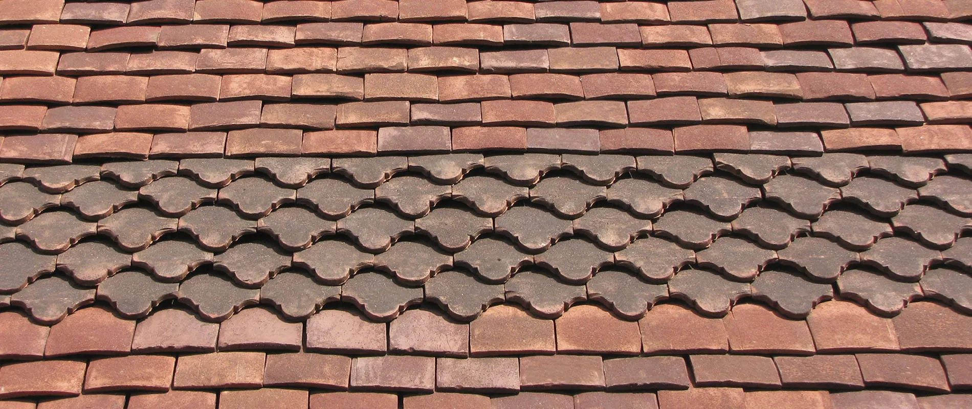 Courses of Tudor handmade clay plain tiles on a finished roof